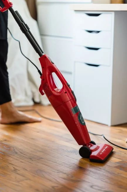 services-04 Une femme de chambre dispose des coussins dans une chambre d'hôtel somptueuse, mettant en avant le confort et le raffinement.